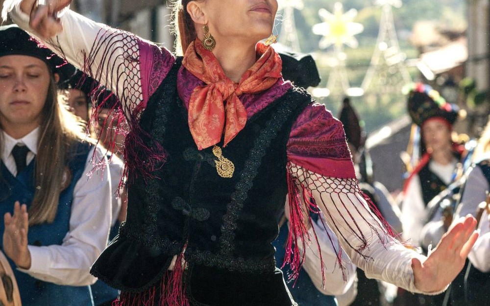 Eine
                                                Frau in Tracht tanzt. 