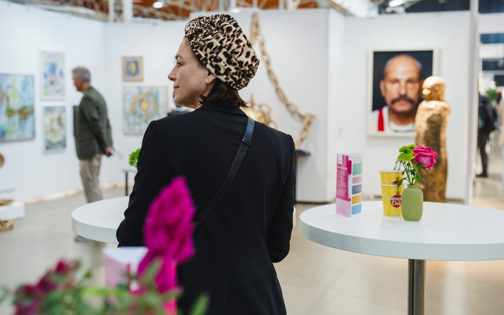 eine Frau sieht sich in der Ausstellungshalle bei der
                                                Affordable Art Fair um